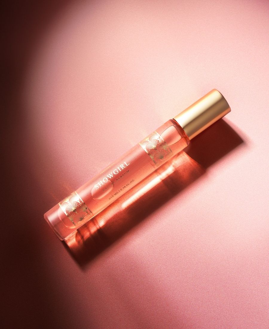 This is a lifestyle image of our Showgirl 10 ml bottle on a pink background.