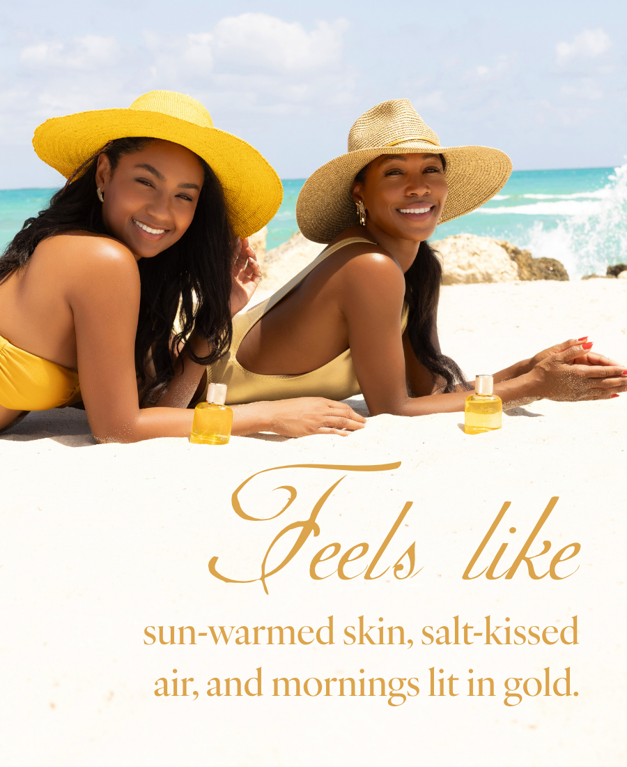 Two women in yellow and gold swimwear on a sunny beach, each with a Golden Muse fragrance bottle. Text reads 'Feels like sun-warmed skin, salt-kissed air, and mornings lit in gold.'