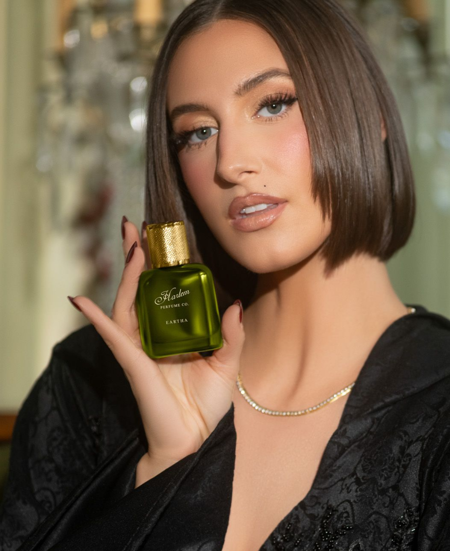 This is an image of our model, Nora Mae, who is Eartha Kitt's granddaughter. She is holding the Eartha perfume bottle.