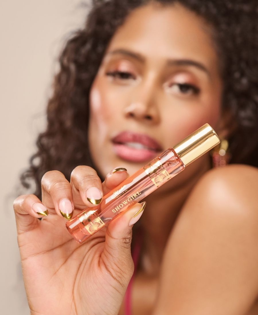 This is an image of a model holding the Showgirl 10 ml bottle in her fingers.