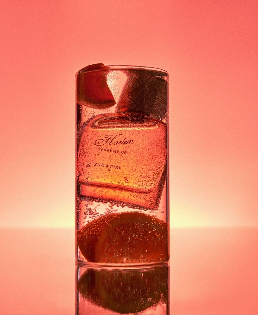 This is a lifestyle image of the Showgirl Eau de Parfum inside a cocktail glass with bubbles.