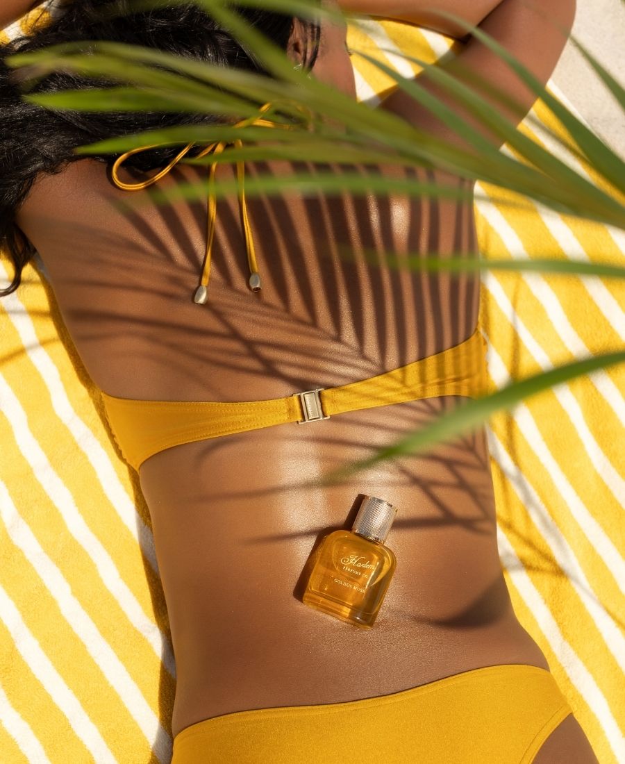 This is an image of our model with the Golden Muse perfume laying on her back.