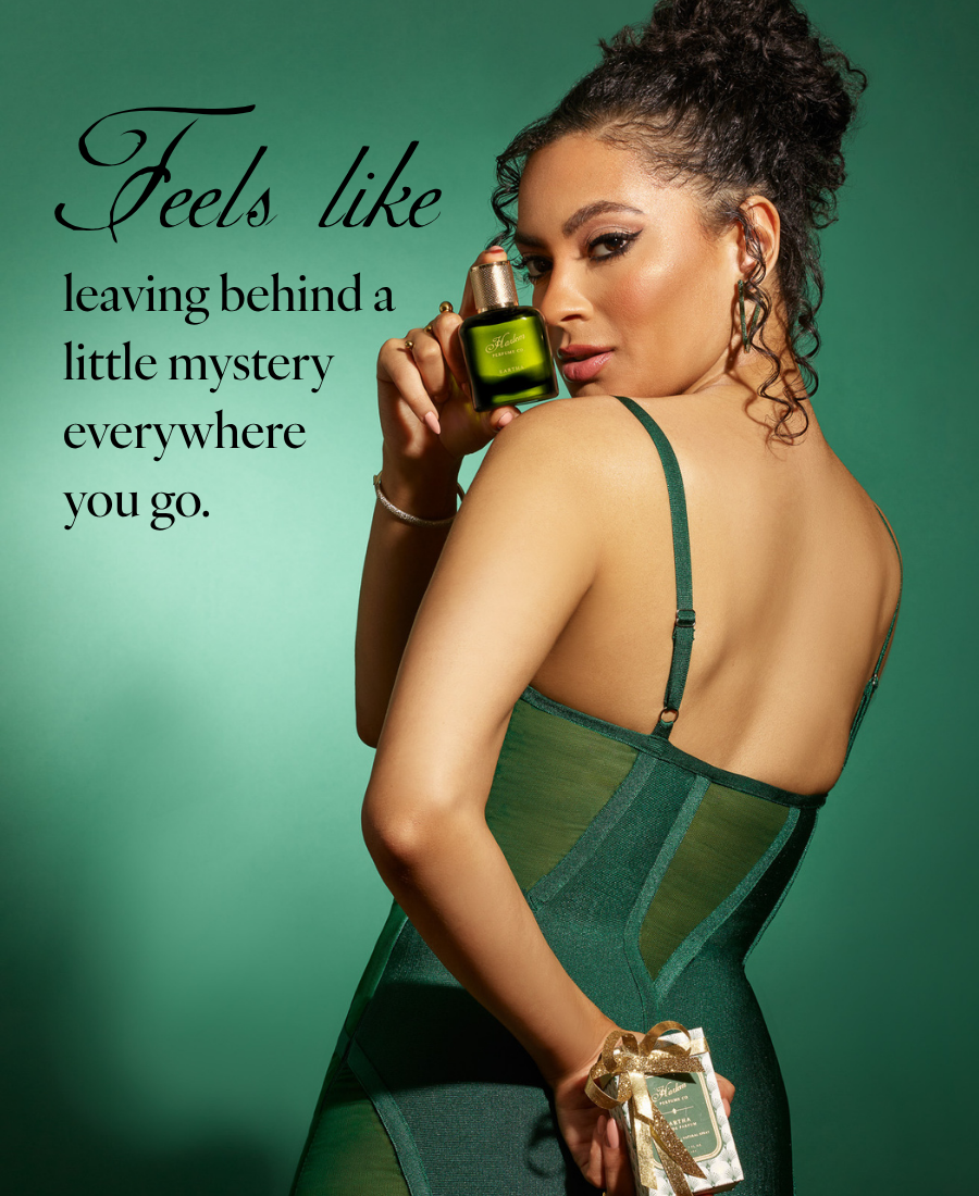 Woman in a green dress holding an Eartha fragrance bottle with overlay text: "Feels like leaving behind a little mystery everywhere you go."