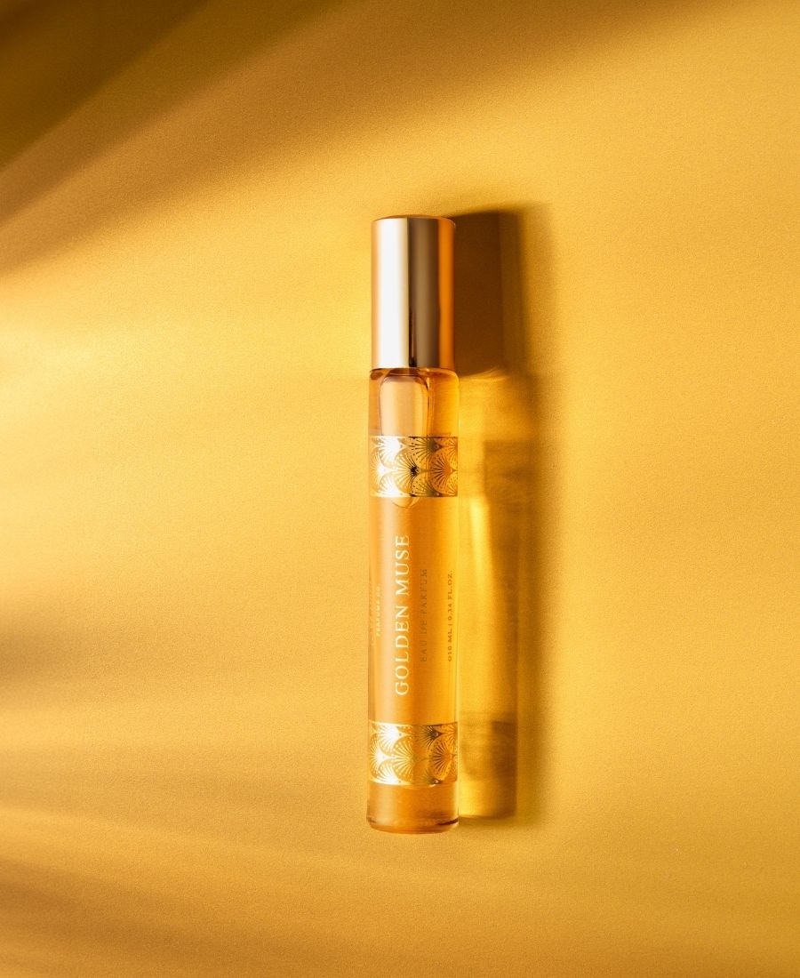 This is a lifestyle image of the 10 ml Golden Muse perfume on a golden background.