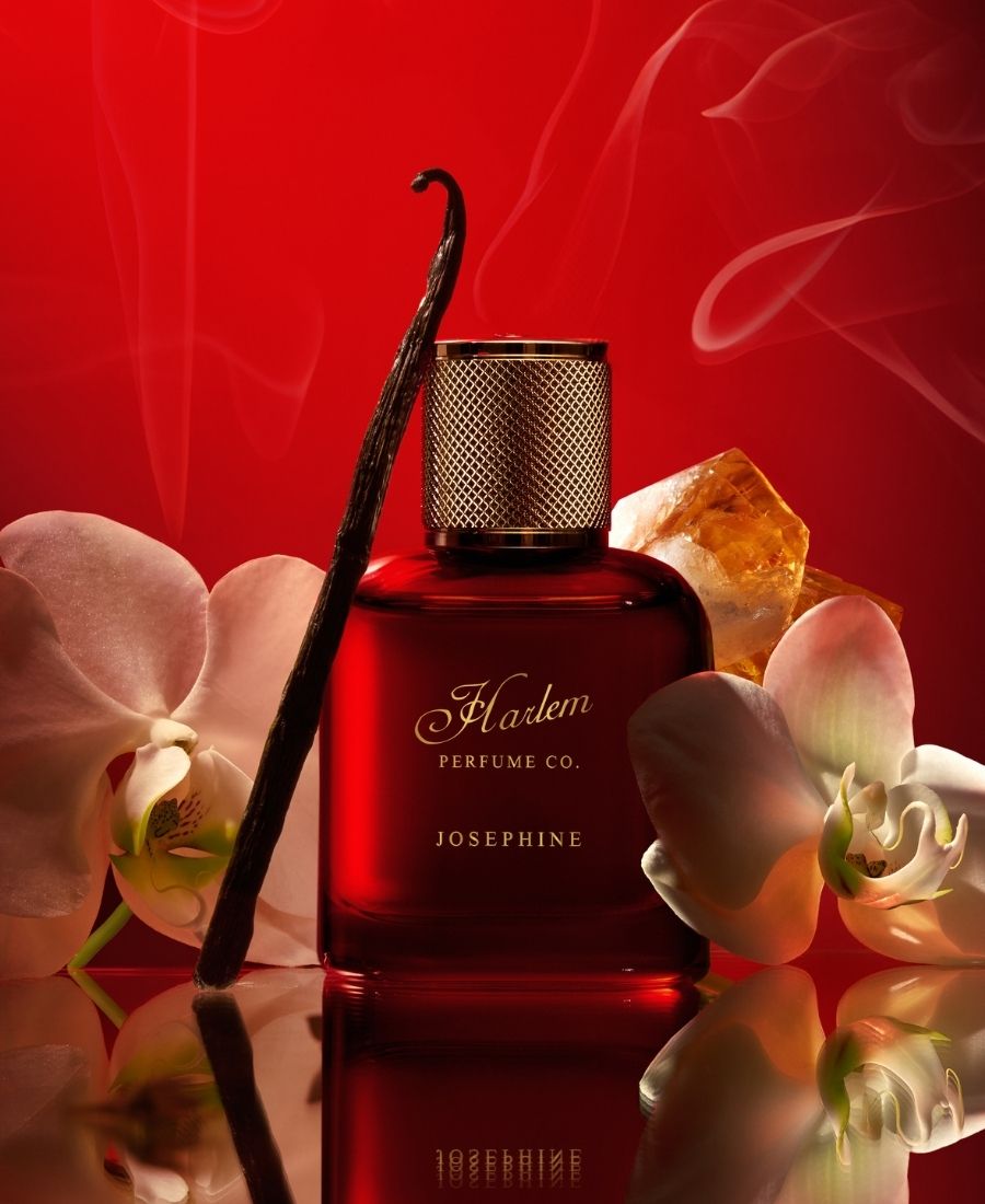 Red perfume bottle labeled 'Harlem Perfume Co. Josephine' with vanilla bean and orchids on a red background